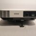 A white Epson projector with HDMI and 3LCD labels on the front, positioned against a plain background.