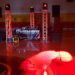 A dimly lit indoor venue with a DJ booth labeled RHINOS in the center features an upgraded sound system flanked by speakers and illuminated truss towers. Red and orange lights project patterns on the floor, with a lone balloon and a banner in the background.